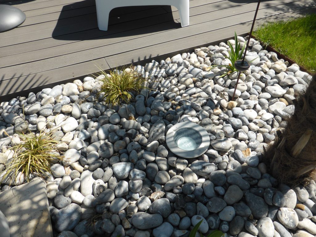 Spot encastré dans un massif minéral près d'une terrasse.
