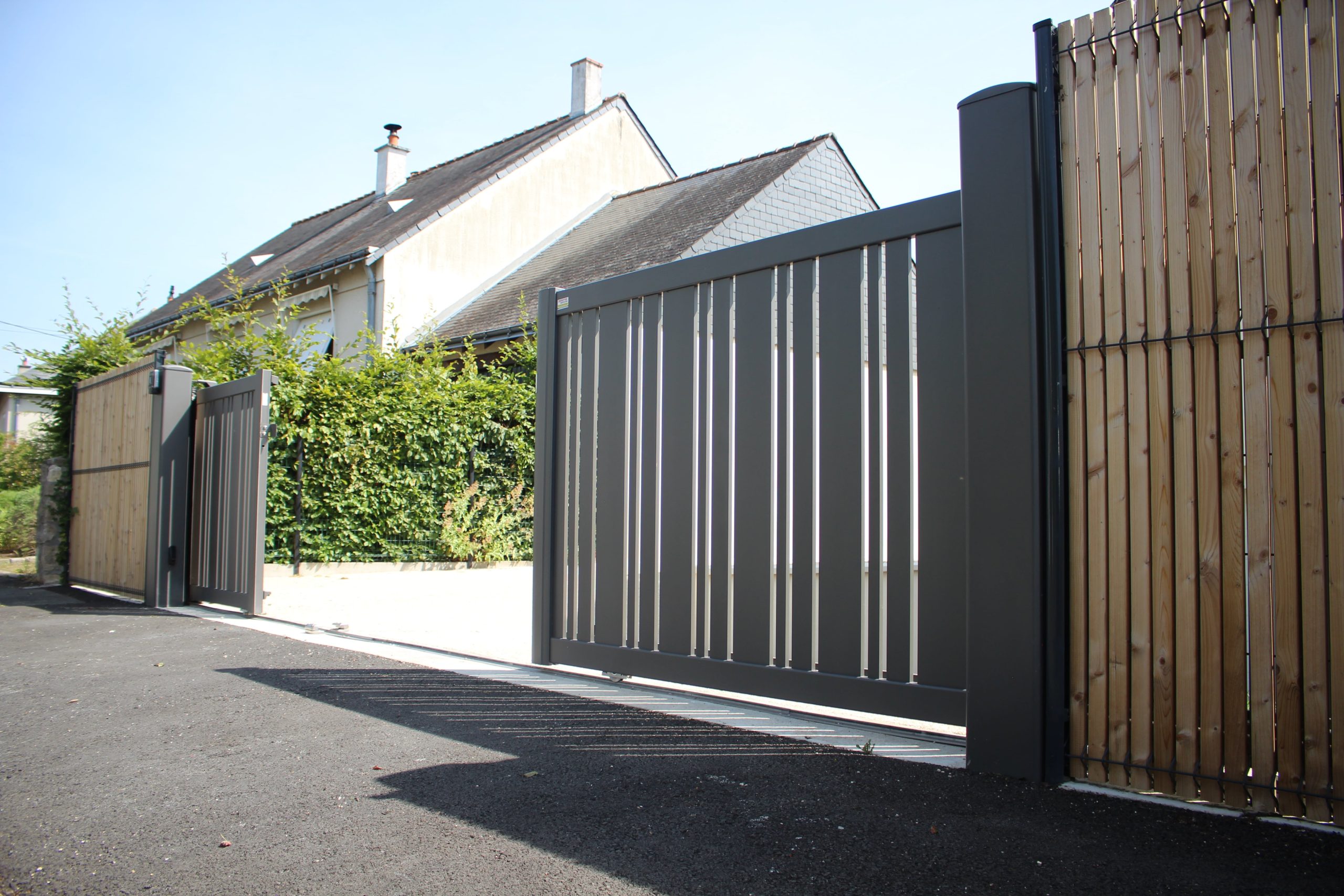 Portail ajouré en aluminium à ouverture antagoniste.